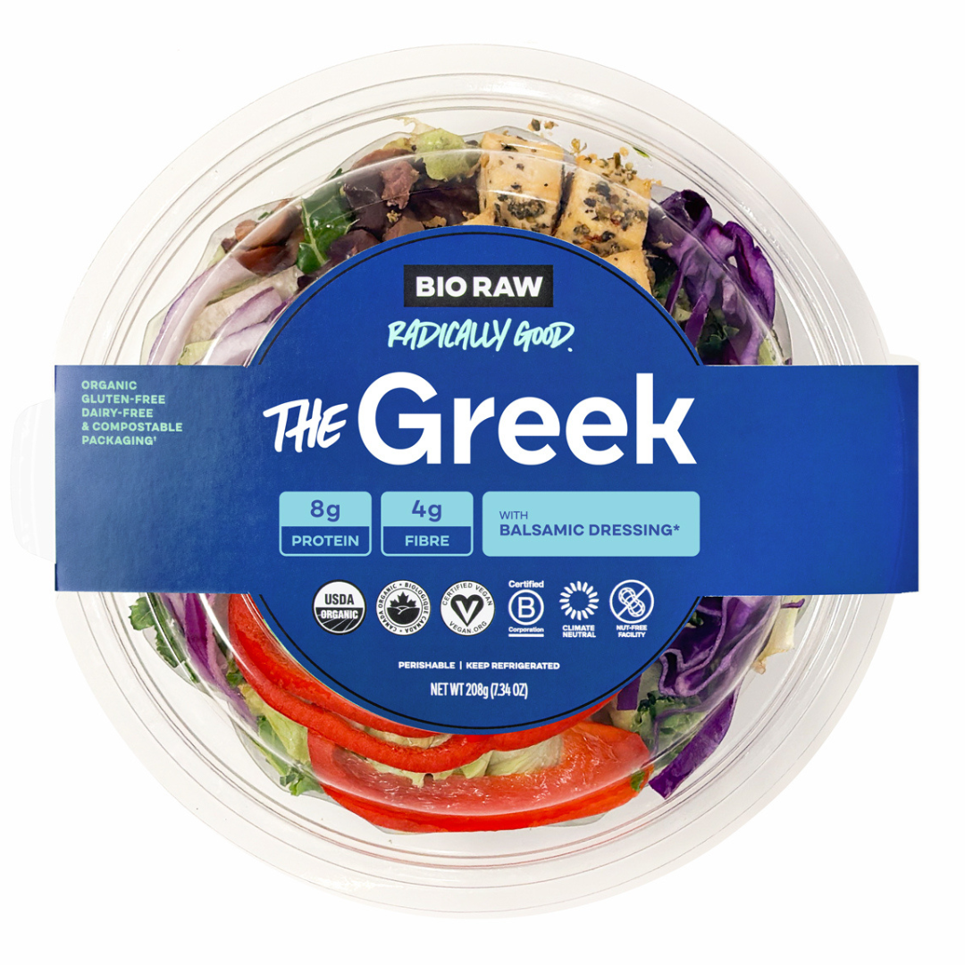 Packaged Greek salad with label indicating organic, gluten-free, dairy-free, and compostable packaging.